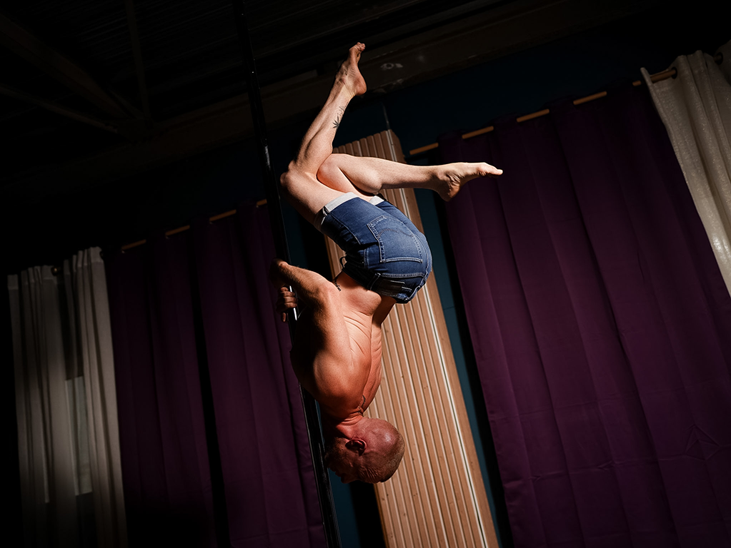 Professeur de pole dance réalisant une figure chez Demon Spin, école de pole dance 91